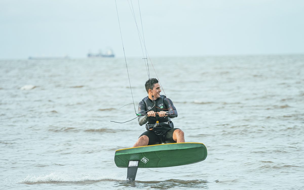 Bruno Lobo sorrindo enquanto navega de kite foil